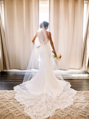 Martina Liana White Lace-Train Wedding Gown with sleeves and veil.